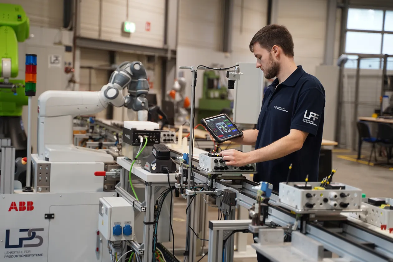 Ein Mann arbeitet in der Lernfabrik an einem Roboter