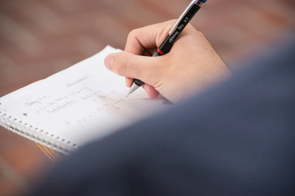 Hand schreibt auf einen Block